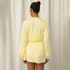 Detail of pale yellow satin robe featuring elegant lace trim on the sleeves and silky texture