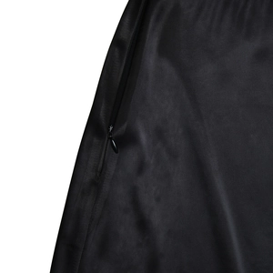 Detail of invisible zipper on sleek black satin skirt with seamless stitching