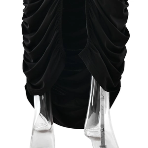 Detailed view of the elegant ruched side seams and slit hem on a black bodycon dress