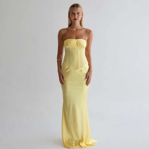 Détail de la robe longue en satin jaune avec bustier structuré et ourlet en queue de poisson