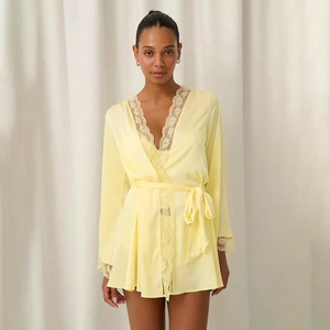 Detailed view of pale yellow silk robe featuring white lace trim and adjustable waist tie