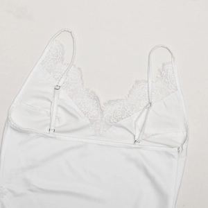 Macro shot of white satin camisole with delicate eyelash lace trim and V-neckline