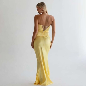 Détail d'une robe de soirée en satin jaune avec dos nu et laçage croisé sophistiqué