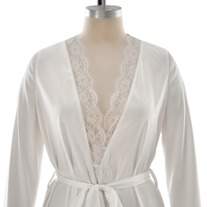 Close-up of white silk satin robe featuring delicate lace trim and adjustable waist tie