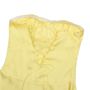 Détail d'une robe bustier en satin jaune avec laçage au dos et fermeture éclair latérale