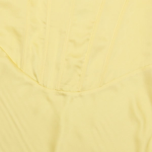 Gros plan détaillé sur tissu en satin jaune avec coutures de style corset vertical
