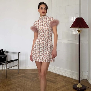 Détail de la mini robe fleurie rose avec poignets en plumes et col montant élégant