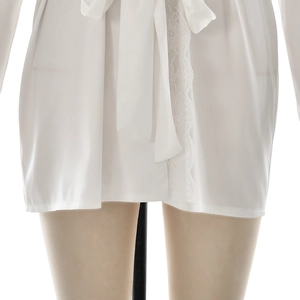 Close-up of white satin loungewear with intricate lace trim and tie waist design