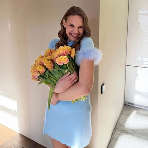 Détail de la robe en maille bleu clair avec poignets en plumes et ourlet festonné