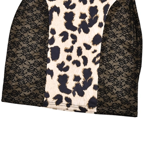 Detail shot of leopard print fabric joined with black floral lace on a slim dress hem