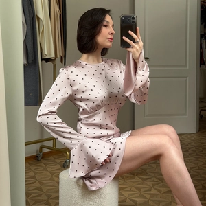 Détail de la robe en satin rose à pois avec manches évasées et taille cintrée élégante