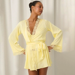 Pale yellow satin robe with floral lace trim and waist tie shown on a model