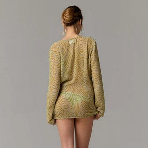 Vue arrière d'une robe de plage semi-transparente avec motif de vagues vert et blanc