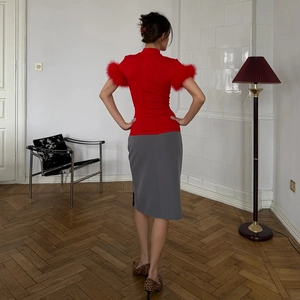 Detailed back view of red high neck short sleeve top with fluffy feather trim on cuffs