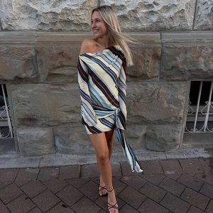 Detail of one-shoulder dress with colorful diagonal stripes and waist knot detail
