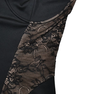 Détail de couture de dentelle florale sur robe moulante noire montrant texture et coutures