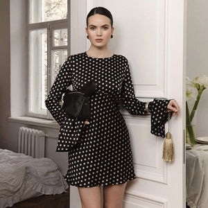 Détail des manches cloches élégantes sur une mini-robe en satin noir à pois pour femme
