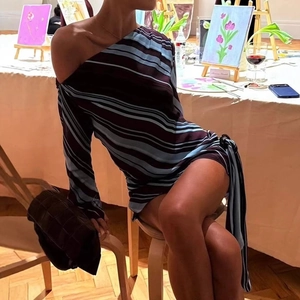 Detail of striped off-shoulder mini dress with side waist tie and tassel elements