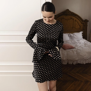 Détails des manches cloche élégantes sur une robe en satin à pois noirs de style rétro