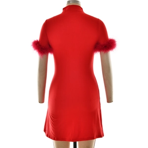 Détail macro de la robe courte rouge avec finitions en plumes élégantes sur les manches