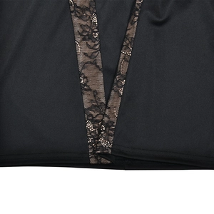 Détail du décolleté en V profond avec empiècement en dentelle florale sur la robe noire