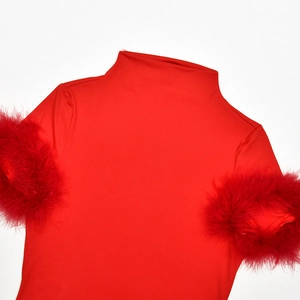 Détail du haut rouge à col montant avec poignets en plumes assortis et maille côtelée