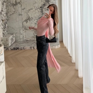 Pink long sleeve top featuring draped neck and long flowing ribbons at the back