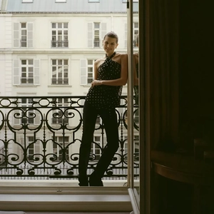 Polka dot halter top paired with slim trousers in a French-style balcony setting
