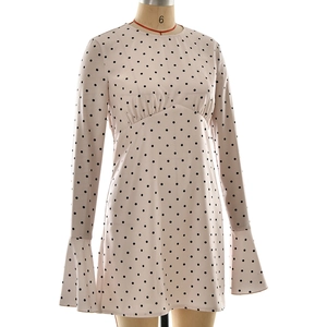 Détail d'une robe en satin rose poudré à pois avec manches cloches et taille haute
