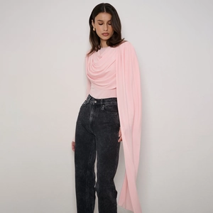 Close-up of light pink long sleeve bodysuit with draped pleats and denim jeans