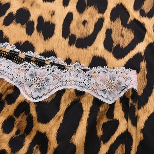 Dettaglio ravvicinato di tessuto leopardato con bordo in pizzo bianco e cuciture