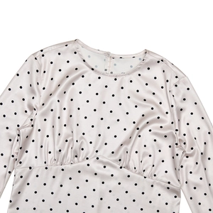 Détail du col rond et de la taille smockée sur cette robe en satin à pois élégante