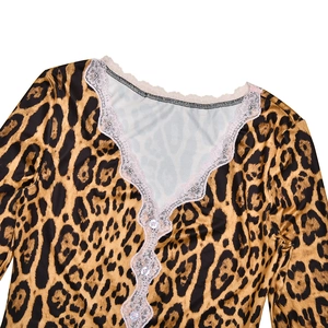 Dettaglio di un top leopardato con bordo in pizzo bianco e bottoni trasparenti eleganti
