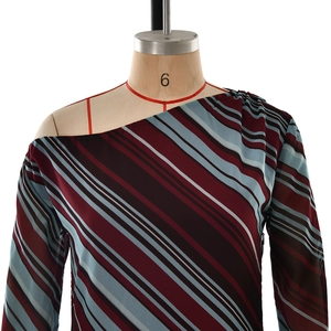 Detail of multi-color diagonal striped off-shoulder dress with metal ring and waist tie