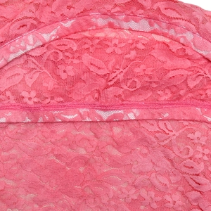 Makrodetail aus rosa Spitzenstoff mit zarten Blumenmustern und feiner Nähkunst am Saum
