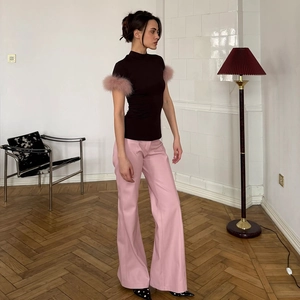 Detail of high-neck slim top featuring fluffy pink feather sleeves and pink wide-leg pants