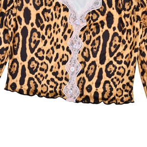 Dettaglio crop top leopardato con bordo in pizzo rosa e bottoni bianchi anteriori