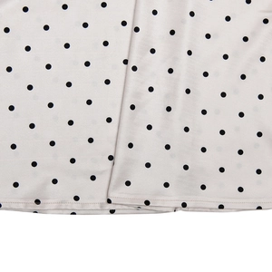 Gros plan du tissu satiné à pois noirs avec détails de couture sur l'ourlet
