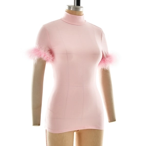 Detail of pink turtleneck top featuring fluffy feather trim on short sleeves for women