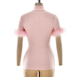 Close-up of high-neck pink slim-fit top featuring stylish fluffy feather trim on the sleeves