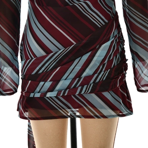 Detail of ruched layering and vibrant diagonal stripes on the mini dress skirt