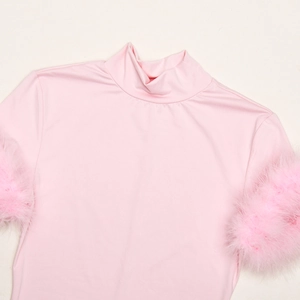 Detail of pink slim-fit turtleneck top featuring fluffy feather trim on the cuffs