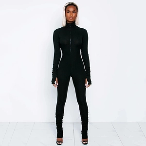 Close-up of black ribbed long sleeve jumpsuit with front zipper and stacked hem details