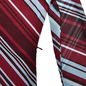 Close-up of the invisible zipper detail on a striped one-shoulder dress with fine texture