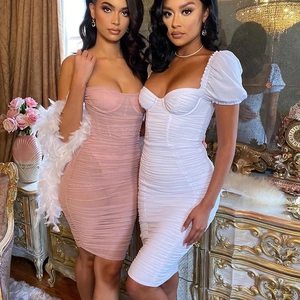 Detail of ruched bodycon dresses in pink mesh and white puff sleeve styles on models