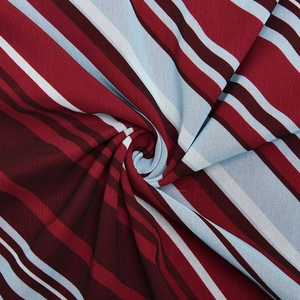 Macro detail of breathable striped chiffon fabric in deep red and light blue tones