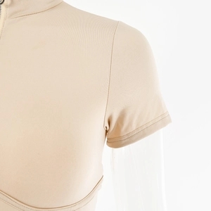 Detail of beige ribbed bodysuit with half-high collar and front zipper closure