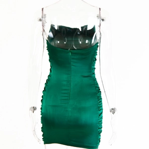 Détails d'une robe moulante en satin vert émeraude avec fronces et zip au dos