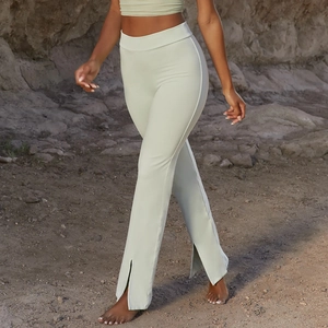 Détail d'un pantalon de yoga vert sauge à taille haute avec fente frontale et coupe évasée