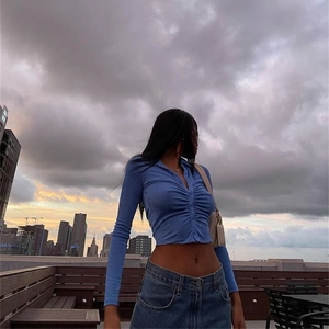 Detail of blue cropped knit top showing ribbed fabric, button down and ruched front design